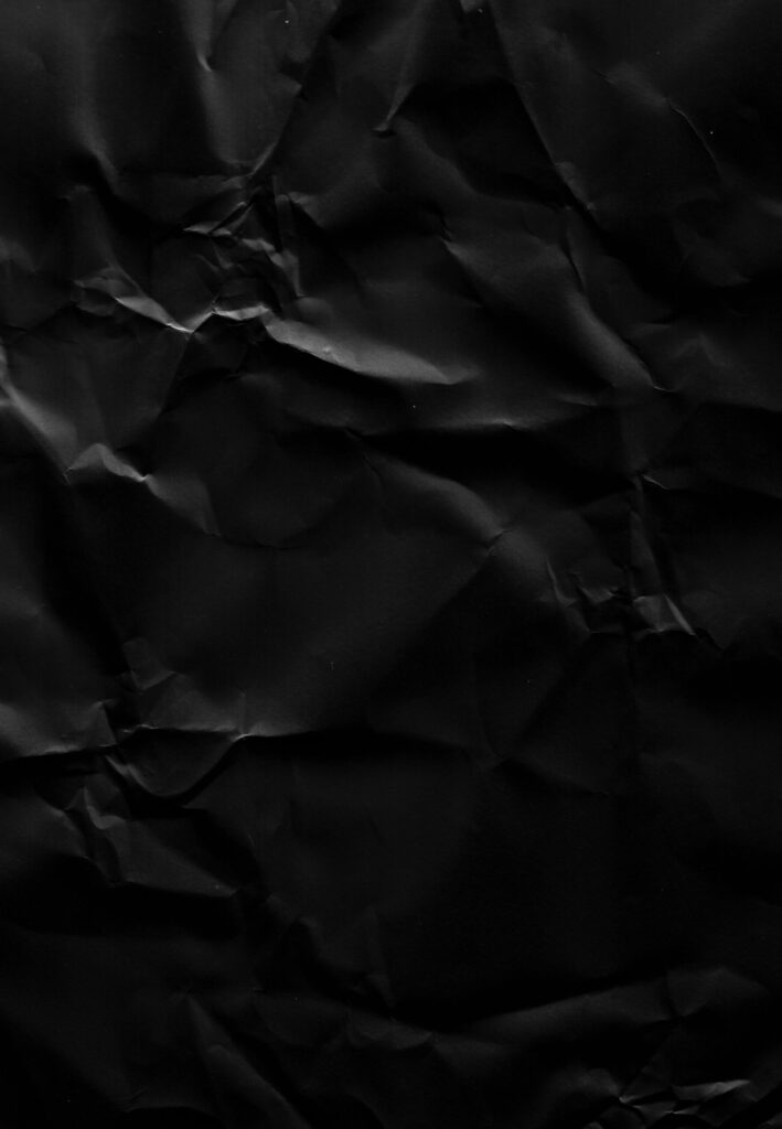 High-resolution crumpled black paper texture perfect for overlays and backgrounds.